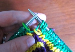 Slip the second loop of the last stitch to the right needle (do not knit it) and remove the marker.