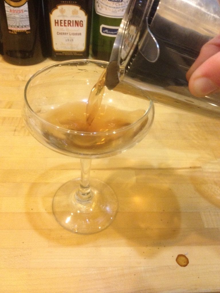 Holding the strainer in place, pour.
