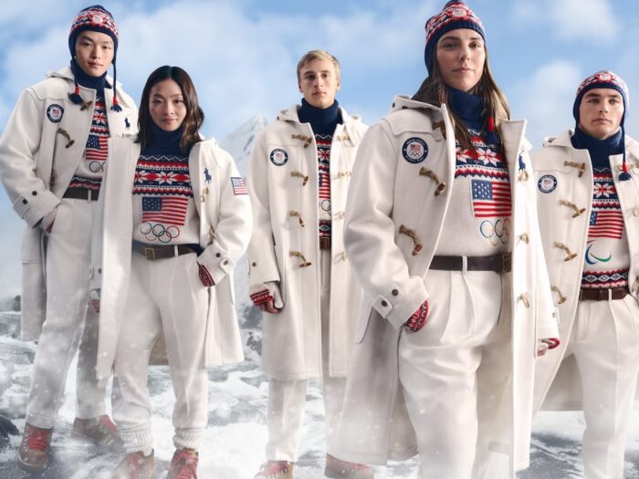 Three men and two women model the 2026 Team USA Olympics uniforms designed by Ralph Lauren, with blue, red and white colorwork hats and sweaters worn with long white coats and white pants.