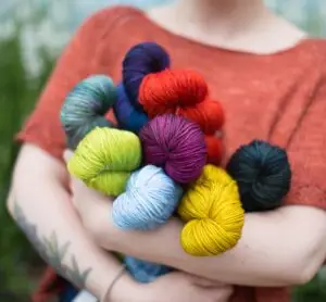 Fibre Space yarnista Allison hugs skeins of Malabrigo Rios.