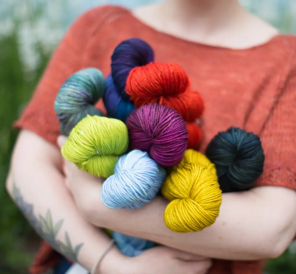 Fibre Space yarnista Allison hugs skeins of Malabrigo Rios.