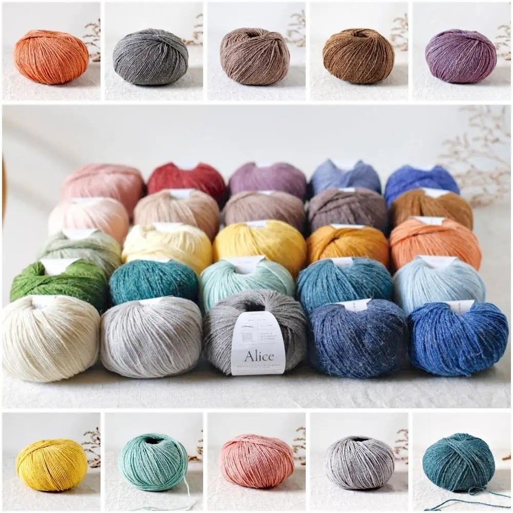 Balls of De Rerum Natura Alice yarn on a linen-covered table.