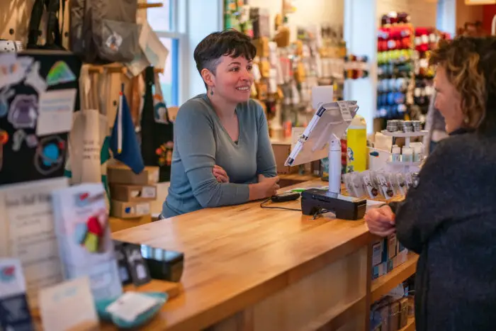 Linda at cash register checking out a customer