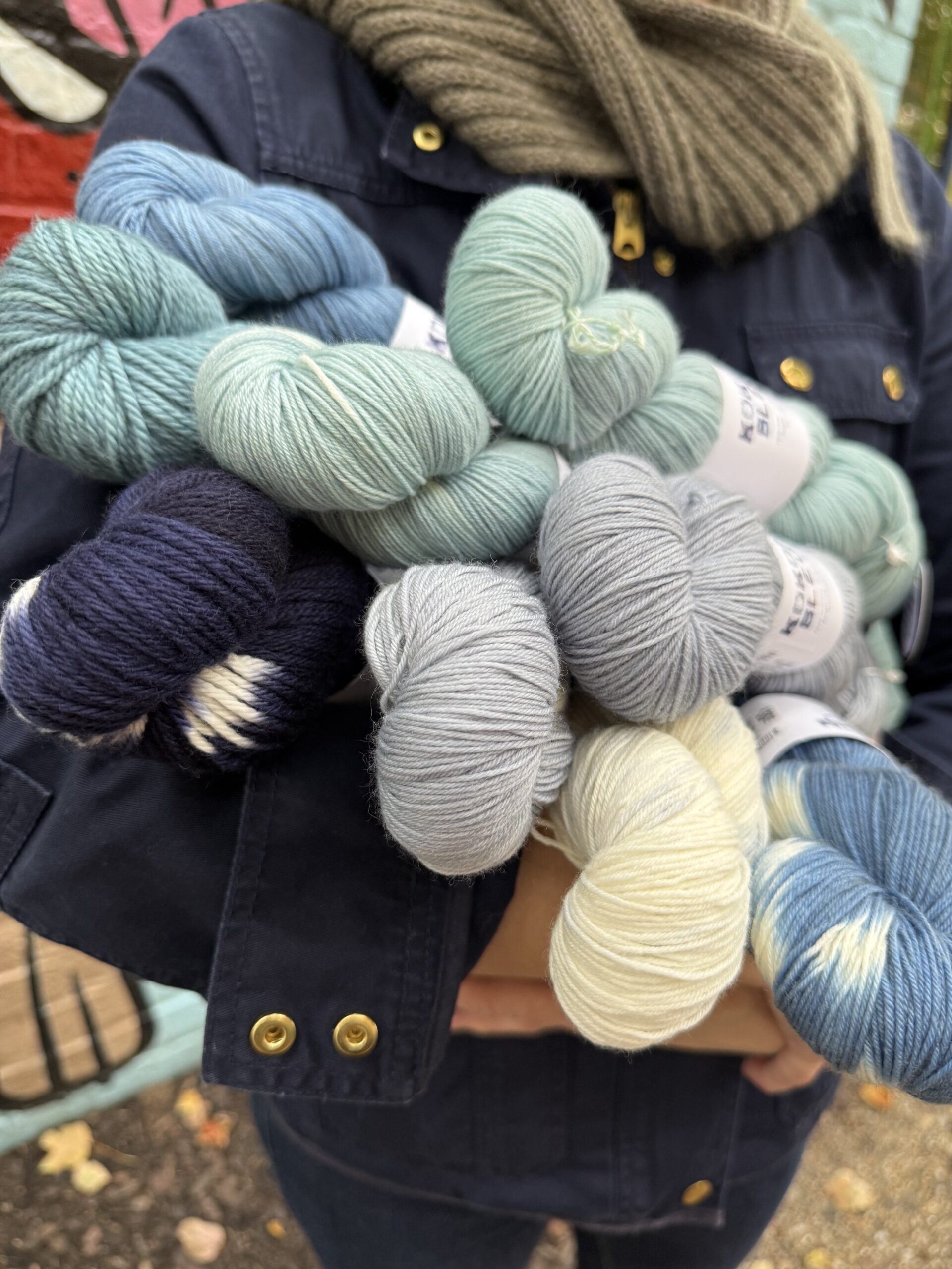 Skeins of Kokon Bleu fingering sock, fingering non-superwash, DK, and Aran in semi-solid, tie-dye, and speckle shades of blue