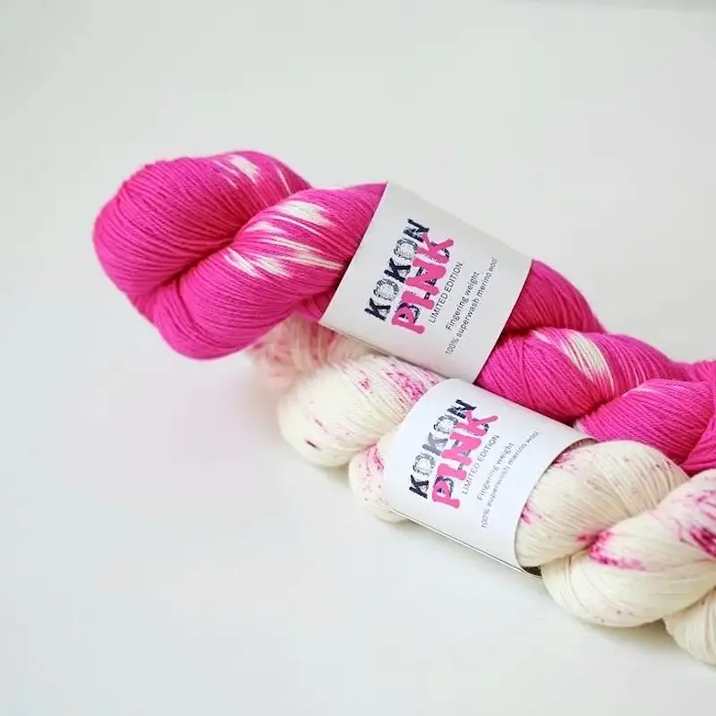 Two skeins of Kokon Pink yarn in pink-speckled white and bright pink tie-dye