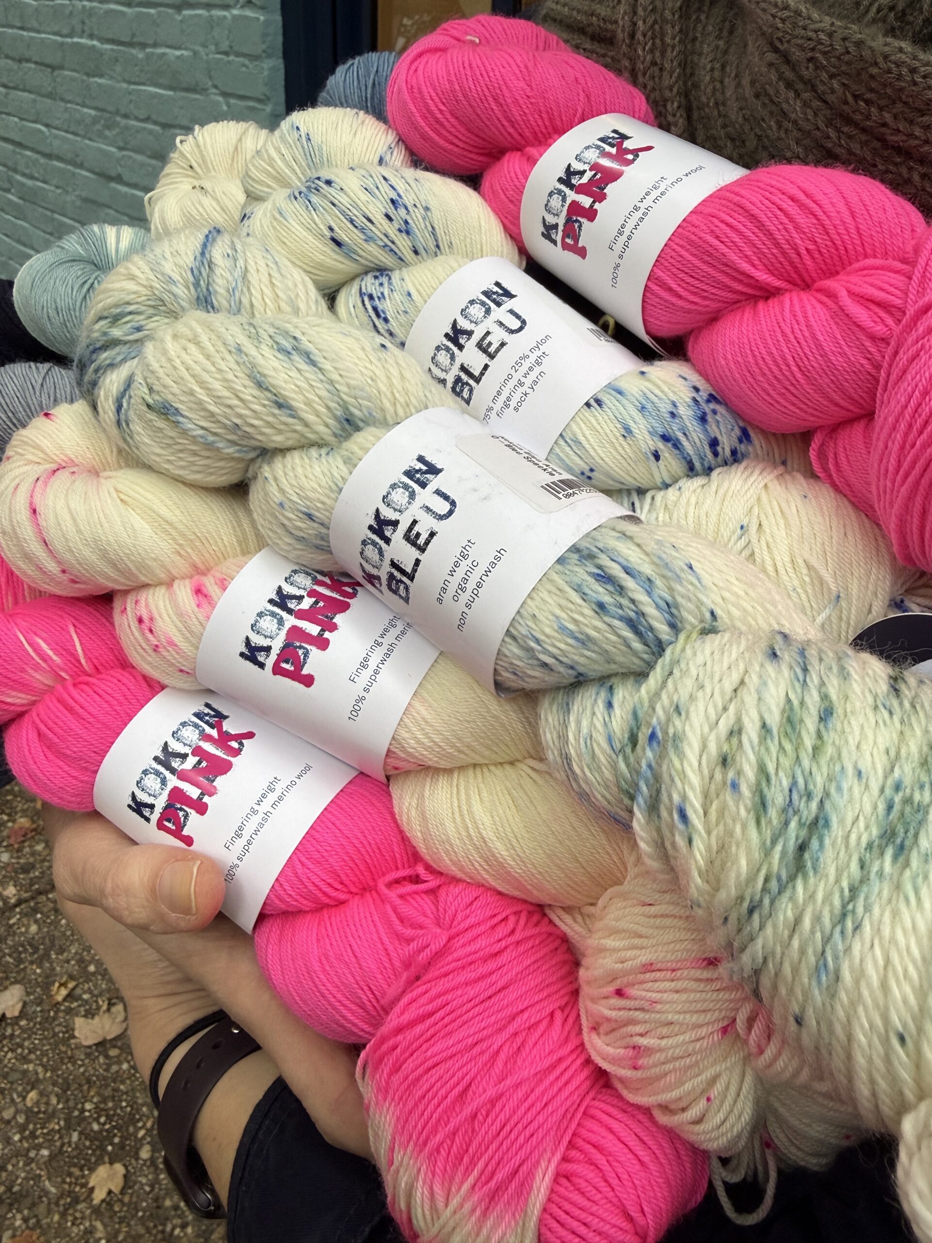 Skeins of Kokon Pink and Blue speckled yarns are sandwiched with Kokon Pink tie-dye and semi-solid skeins